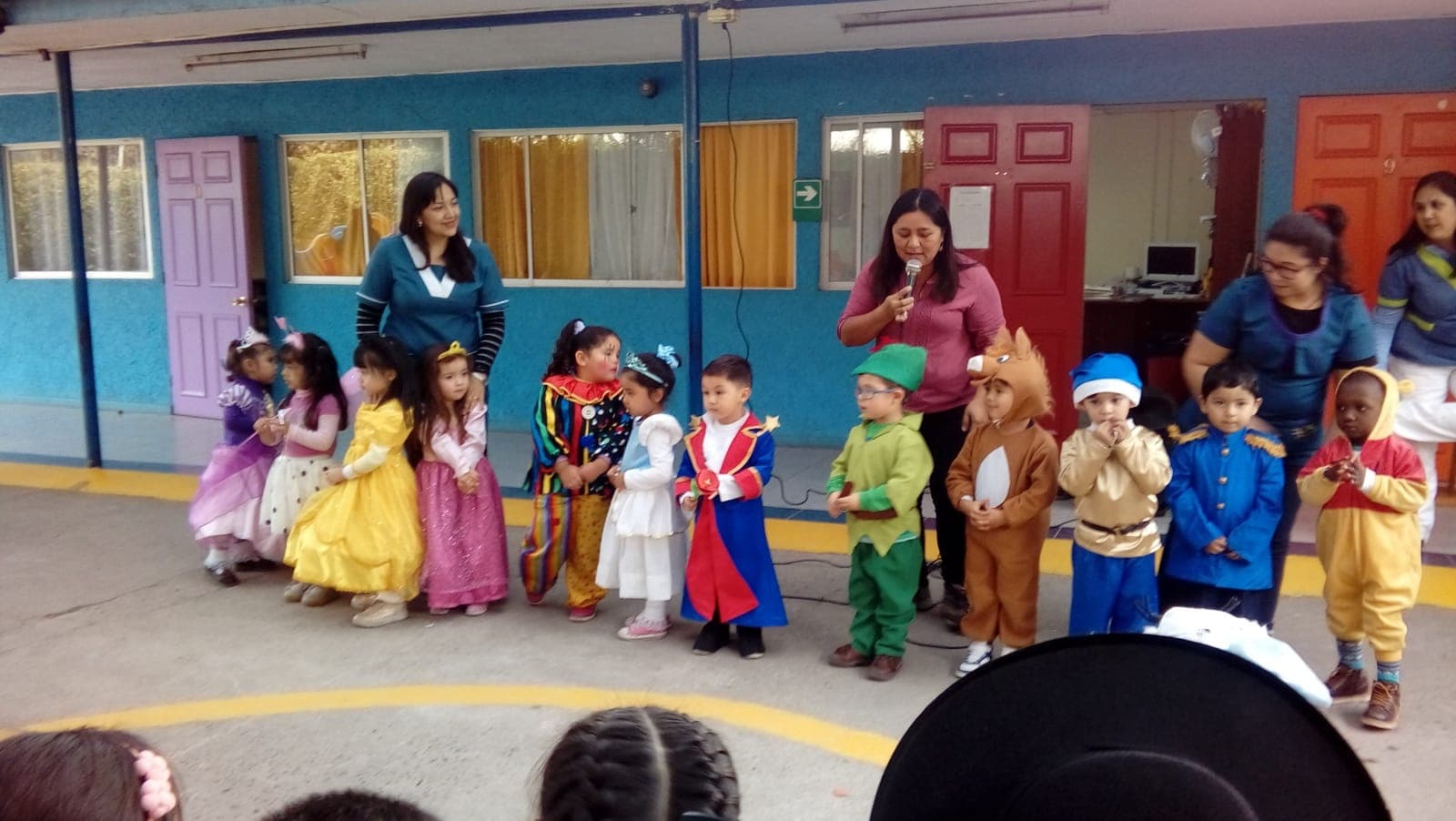 Niños disfrazados de personajes de cuentos se presentan en el patio junto a sus tías y educadoras.